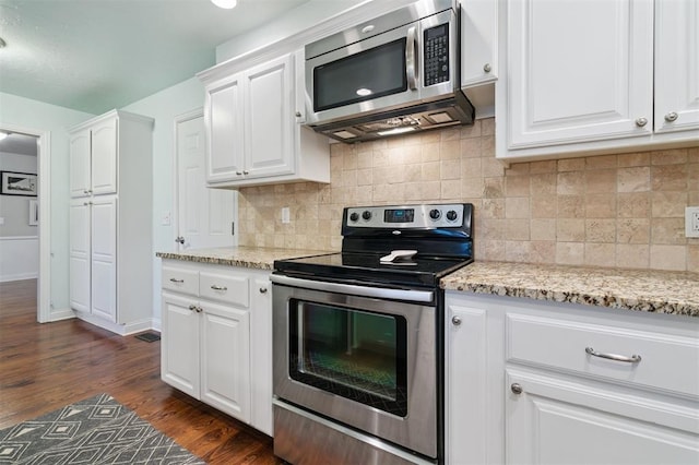 2633 Chaucer Dr, The Village, OK 73120 - kitchen with stainless steel appliances, white cabinets, dark wood-type flooring, tasteful backsplash, and light stone counters