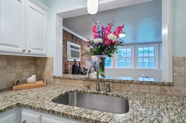 2633 Chaucer Dr, The Village, OK 73120 - kitchen featuring light stone counters, tasteful backsplash, white cabinets, and an AC wall unit