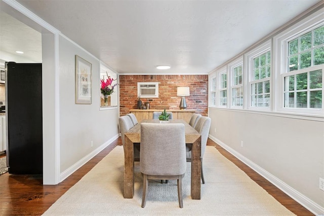 2633 Chaucer Dr, The Village, OK 73120 - dining room featuring dark wood-type flooring, brick wall, an AC wall unit, and crown molding
