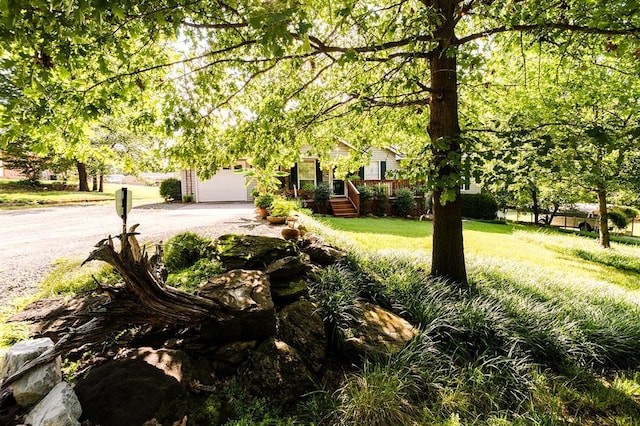 207 S Mcclure Ave, Pauls Valley, OK 73075 - view of green lawn featuring driveway and a garage