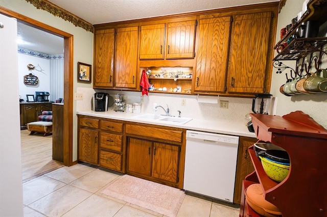 207 S Mcclure Ave, Pauls Valley, OK 73075 - kitchen with white dishwasher, brown cabinetry, light countertops, and a textured ceiling