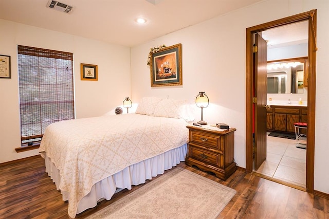 207 S Mcclure Ave, Pauls Valley, OK 73075 - bedroom with dark wood-type flooring, connected bathroom, and recessed lighting