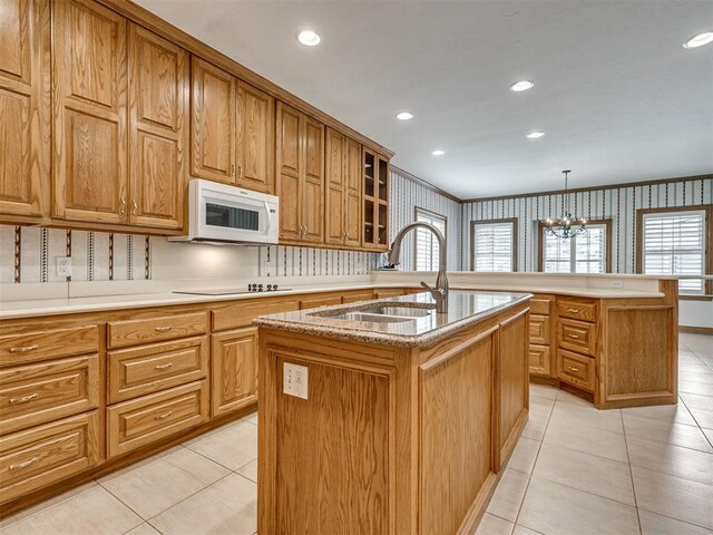 1602 N Davis Ave, Oklahoma City, OK 73127 - kitchen featuring white microwave, an island with sink, light tile patterned flooring, black electric stovetop, and a chandelier