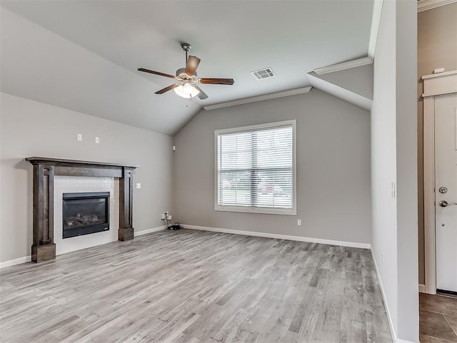8612 SW 36th Ter, Oklahoma City, OK 73179 - unfurnished living room featuring ceiling fan, vaulted ceiling, wood finished floors, a glass covered fireplace, and crown molding