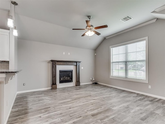 8612 SW 36th Ter, Oklahoma City, OK 73179 - unfurnished living room with vaulted ceiling, ceiling fan, light wood-style floors, a glass covered fireplace, and ornamental molding