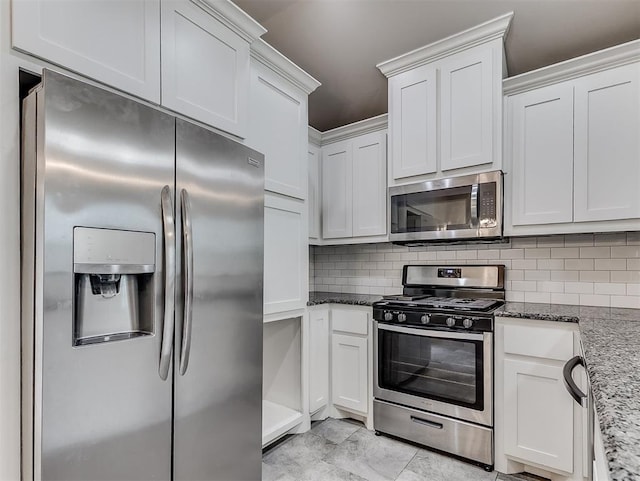8612 SW 36th Ter, Oklahoma City, OK 73179 - kitchen featuring appliances with stainless steel finishes, decorative backsplash, light stone countertops, and white cabinetry