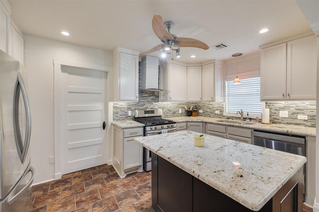 615 NW 26th St, Oklahoma City, OK 73103 - kitchen with stainless steel appliances, wall chimney exhaust hood, a ceiling fan, tasteful backsplash, and recessed lighting