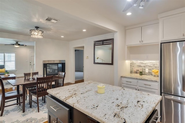 615 NW 26th St, Oklahoma City, OK 73103 - kitchen with freestanding refrigerator, ceiling fan, white cabinetry, light stone counters, and recessed lighting