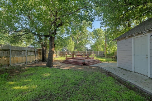 615 NW 26th St, Oklahoma City, OK 73103 - fenced backyard featuring a wooden deck and an outbuilding