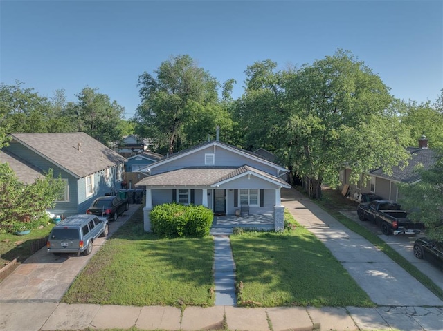 615 NW 26th St, Oklahoma City, OK 73103 - bungalow-style house featuring a front lawn, driveway, and a porch