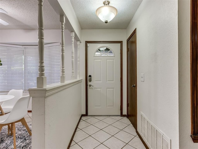 501 E Cardinal Pl, Midwest City, OK 73130 - doorway with a textured ceiling and light tile patterned floors