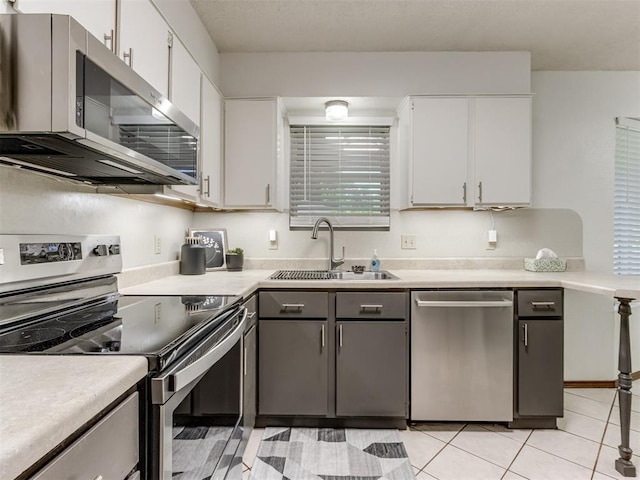 501 E Cardinal Pl, Midwest City, OK 73130 - kitchen with stainless steel appliances, light countertops, and white cabinetry