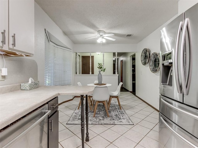 501 E Cardinal Pl, Midwest City, OK 73130 - kitchen with stainless steel appliances, light countertops, ceiling fan, a textured ceiling, and light tile patterned flooring