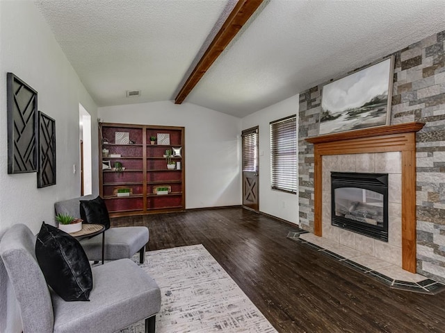 501 E Cardinal Pl, Midwest City, OK 73130 - living area featuring wood finished floors, a tiled fireplace, and a textured ceiling