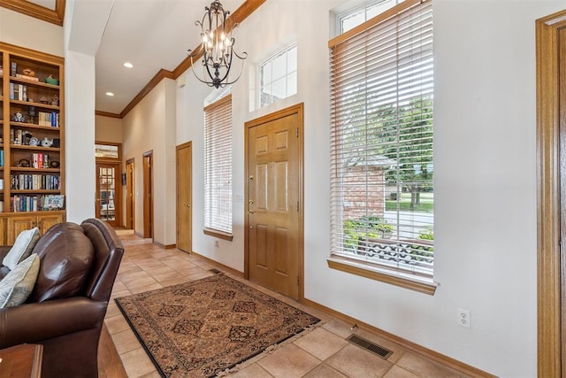 8404 NW 65th Pl, Oklahoma City, OK 73132 - foyer featuring crown molding, healthy amount of natural light, a high ceiling, a chandelier, and light tile patterned flooring