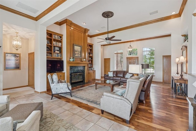 8404 NW 65th Pl, Oklahoma City, OK 73132 - living area featuring a chandelier, a high end fireplace, crown molding, ceiling fan, and wood finished floors