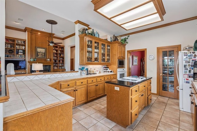 8404 NW 65th Pl, Oklahoma City, OK 73132 - kitchen with white appliances, crown molding, a kitchen island, decorative backsplash, and ceiling fan