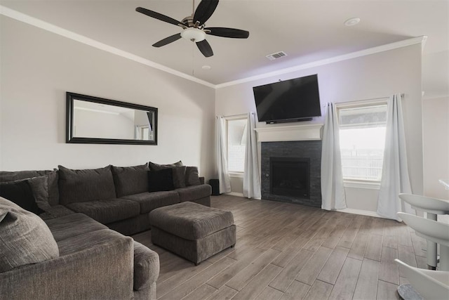 8317 Poplar Dr, Edmond, OK 73034 - living area featuring a ceiling fan, wood finished floors, crown molding, and a tile fireplace