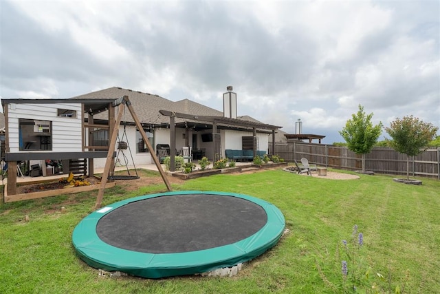 8317 Poplar Dr, Edmond, OK 73034 - rear view of house featuring a trampoline, a chimney, a patio, an outdoor fire pit, and roof with shingles