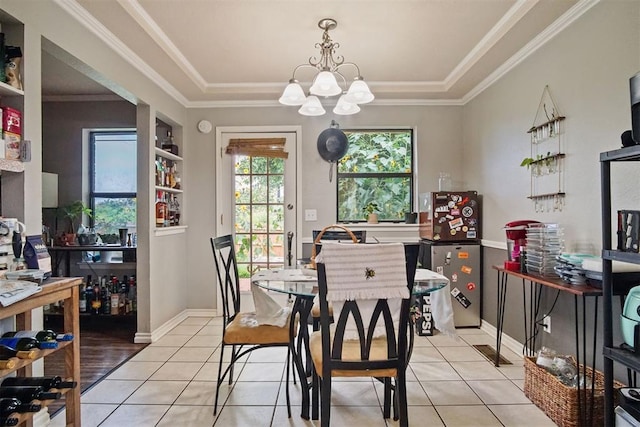 1713 Apian Way, Edmond, OK 73003 - dining area with a chandelier, a tray ceiling, light tile patterned floors, and crown molding