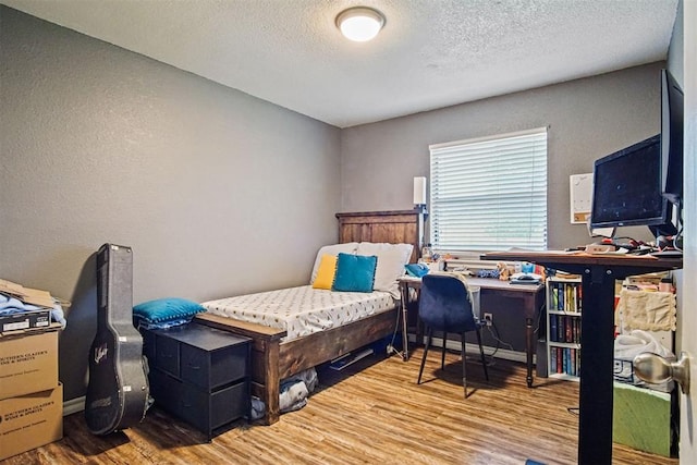 1713 Apian Way, Edmond, OK 73003 - bedroom featuring wood finished floors, a textured ceiling, and a textured wall