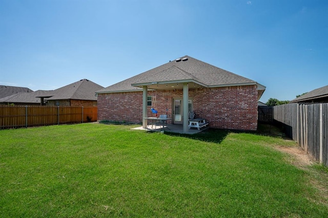321 SW 147th St, Oklahoma City, OK 73160 - back of property with a fenced backyard, a patio area, a shingled roof, and brick siding