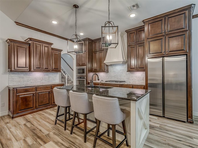 1470 Auburn Cir, Piedmont, OK 73078 - kitchen with built in appliances, tasteful backsplash, dark stone countertops, custom range hood, and recessed lighting