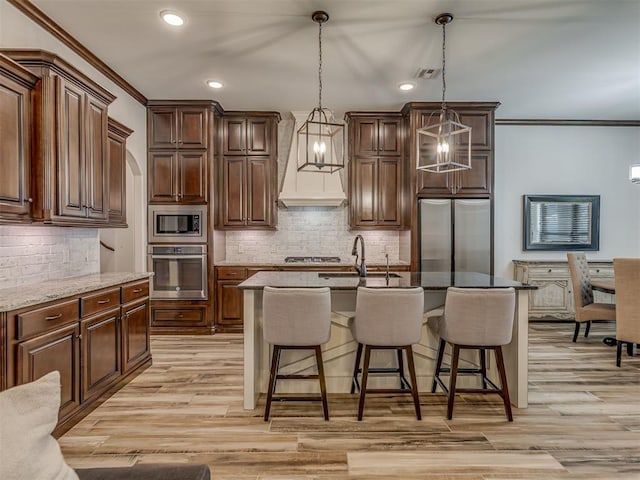 1470 Auburn Cir, Piedmont, OK 73078 - kitchen with stainless steel appliances, crown molding, tasteful backsplash, premium range hood, and a kitchen breakfast bar