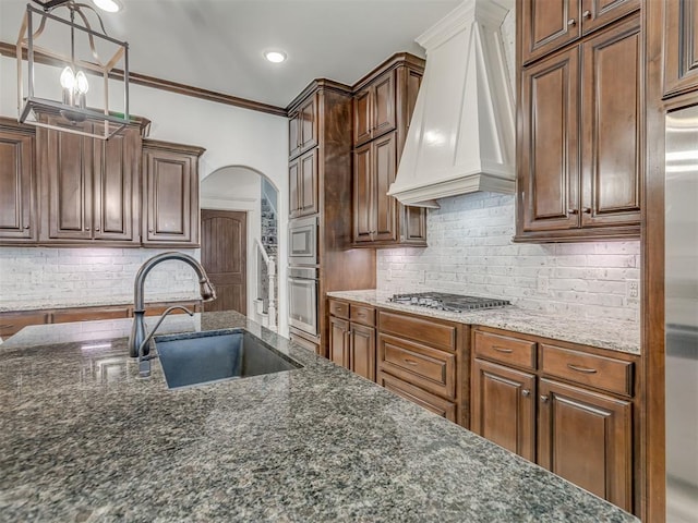 1470 Auburn Cir, Piedmont, OK 73078 - kitchen featuring custom exhaust hood, appliances with stainless steel finishes, arched walkways, dark stone counters, and decorative backsplash