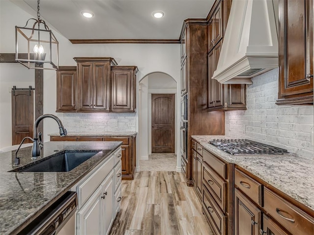 1470 Auburn Cir, Piedmont, OK 73078 - kitchen with custom exhaust hood, appliances with stainless steel finishes, dark stone counters, backsplash, and decorative light fixtures
