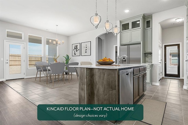 1416 SW 160th St, Moore, OK 73170 - kitchen featuring arched walkways, appliances with stainless steel finishes, light countertops, a chandelier, and a center island with sink