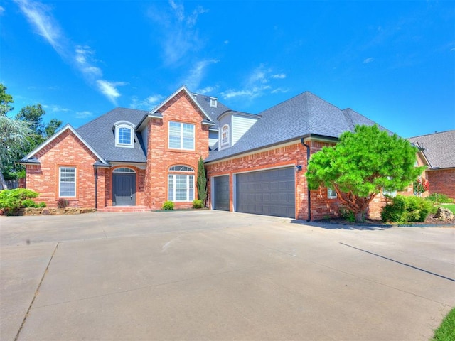 1008 Bentbrook Pl, Norman, OK 73072 - view of front of home featuring brick siding, an attached garage, a shingled roof, and driveway