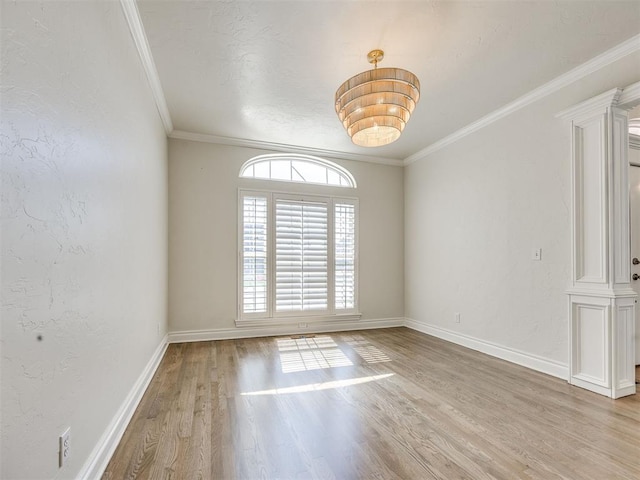 1008 Bentbrook Pl, Norman, OK 73072 - spare room featuring light wood-style flooring, crown molding, a chandelier, and ornate columns