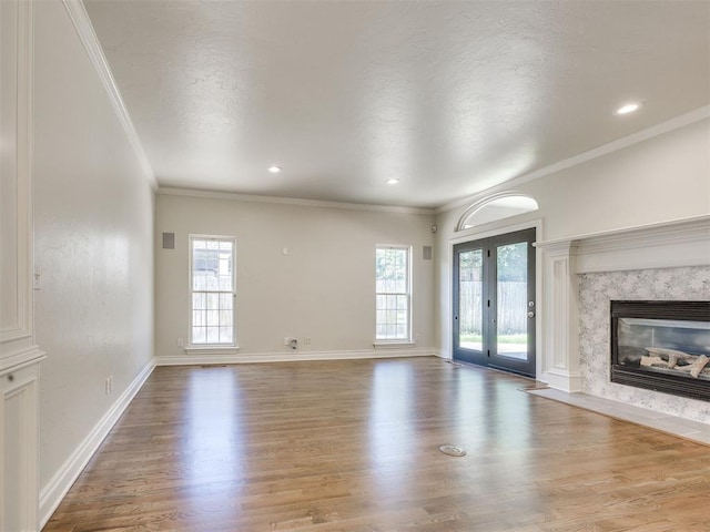 1008 Bentbrook Pl, Norman, OK 73072 - unfurnished living room with wood finished floors, plenty of natural light, ornamental molding, a premium fireplace, and recessed lighting