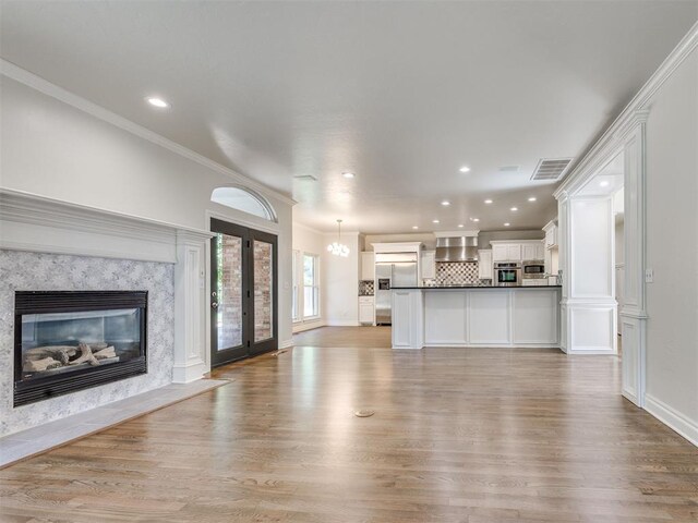 1008 Bentbrook Pl, Norman, OK 73072 - unfurnished living room featuring light wood-type flooring, a fireplace, recessed lighting, and ornamental molding