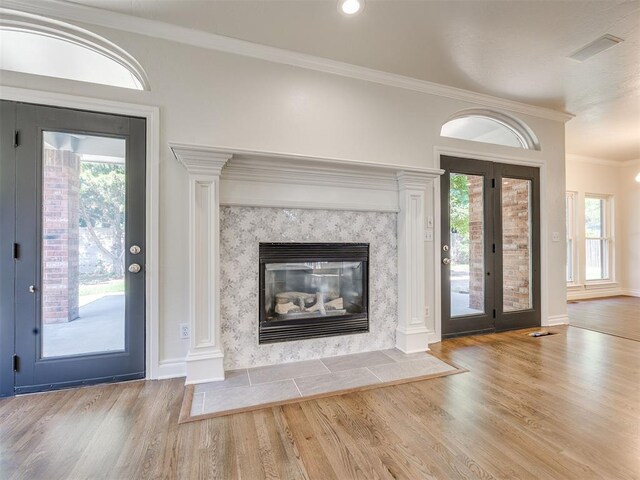1008 Bentbrook Pl, Norman, OK 73072 - foyer entrance featuring wood finished floors, ornamental molding, healthy amount of natural light, and a fireplace