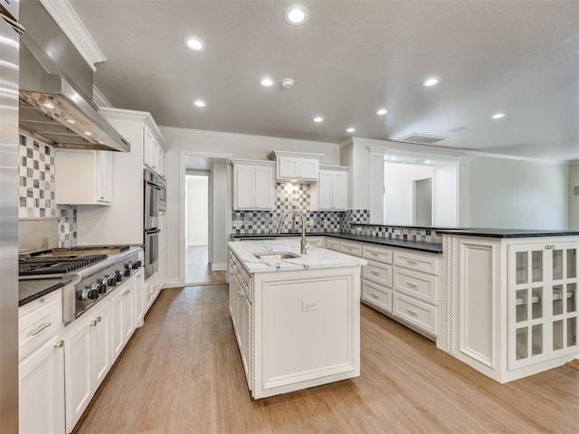 1008 Bentbrook Pl, Norman, OK 73072 - kitchen featuring appliances with stainless steel finishes, range hood, ornamental molding, backsplash, and an island with sink