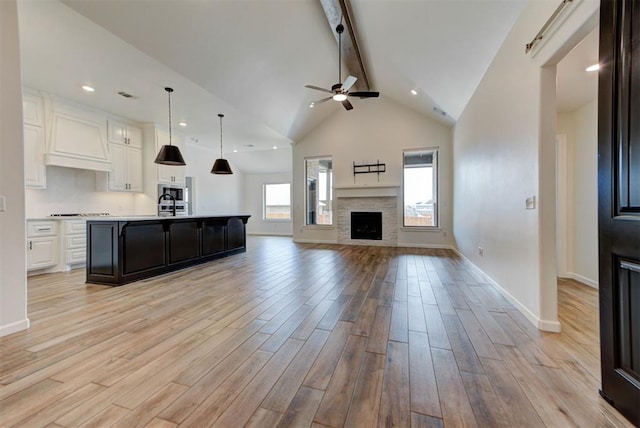 1632 NE 35th St, Moore, OK 73160 - unfurnished living room with beam ceiling, ceiling fan, light wood finished floors, a fireplace, and high vaulted ceiling