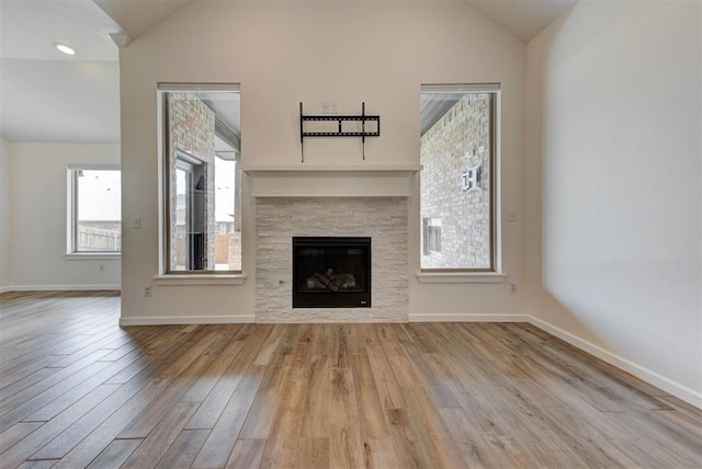 1632 NE 35th St, Moore, OK 73160 - unfurnished living room featuring vaulted ceiling, wood finished floors, and a stone fireplace
