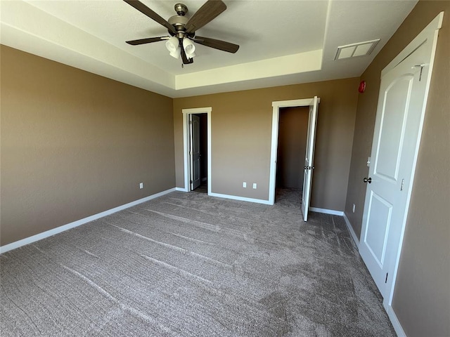1808 Sommerset Pl, Altus, OK 73521 - unfurnished bedroom featuring a tray ceiling, carpet, and a ceiling fan