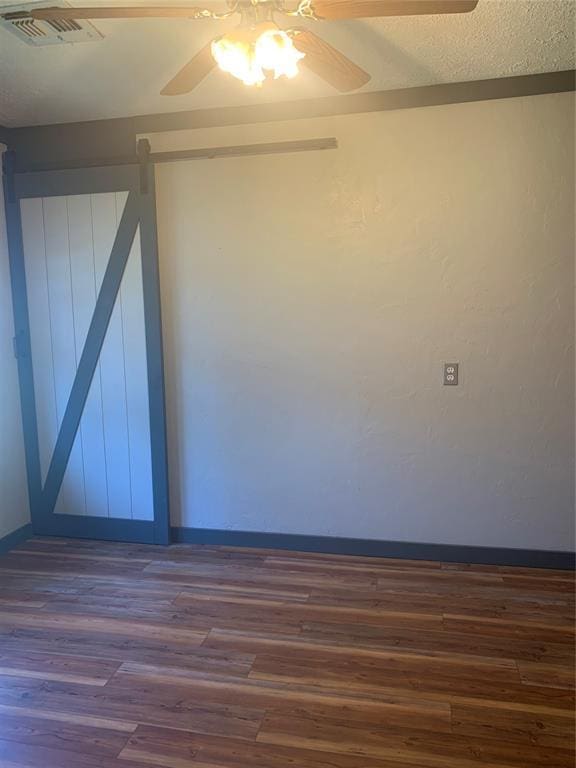 28153 County Street 2540Th, St, Fort Cobb, OK 73038 - empty room featuring dark wood-style floors, ceiling fan, and a barn door