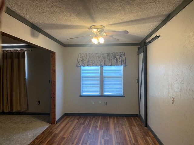 28153 County Street 2540Th, St, Fort Cobb, OK 73038 - empty room featuring dark wood-style floors, a textured ceiling, a ceiling fan, and a barn door