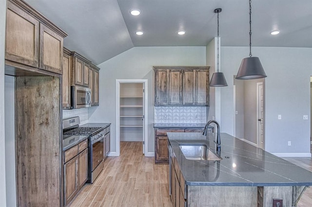6413 SE 84th St, Oklahoma City, OK 73135 - kitchen with stainless steel appliances, dark countertops, light wood finished floors, decorative backsplash, and vaulted ceiling