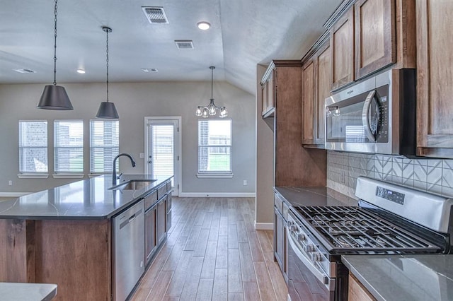 6413 SE 84th St, Oklahoma City, OK 73135 - kitchen with stainless steel appliances, vaulted ceiling, light wood-style floors, a chandelier, and decorative backsplash