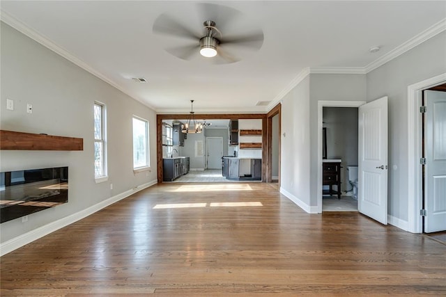 1800 NW 38th St, Oklahoma City, OK 73118 - unfurnished living room featuring a chandelier, ceiling fan, ornamental molding, and wood finished floors