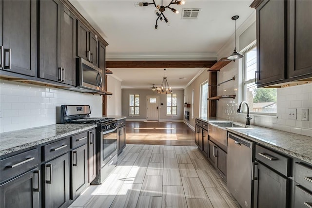 1800 NW 38th St, Oklahoma City, OK 73118 - kitchen with stainless steel appliances, a chandelier, crown molding, dark brown cabinetry, and decorative backsplash