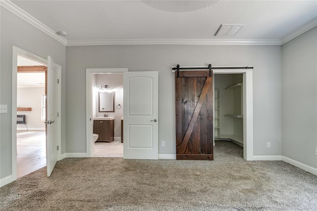 1800 NW 38th St, Oklahoma City, OK 73118 - unfurnished bedroom with carpet flooring, ornamental molding, a barn door, a walk in closet, and connected bathroom