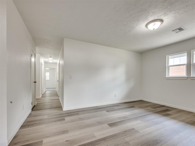 3044 S Madole Blvd, Oklahoma City, OK 73159 - spare room featuring plenty of natural light, light wood finished floors, and a textured ceiling