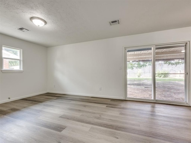 3044 S Madole Blvd, Oklahoma City, OK 73159 - spare room with wood finished floors and a textured ceiling