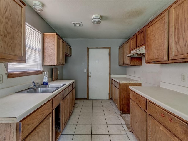 1106 Foggy Bottom Rd, Tecumseh, OK 74873 - kitchen with under cabinet range hood, brown cabinetry, and light countertops